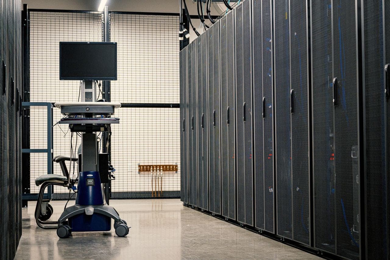 Rows of server cabinets and an equipment trolley in a data centre